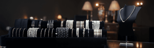 Pearl bracelets, gold bangles, and a necklace neatly arranged on a jewelry rack.